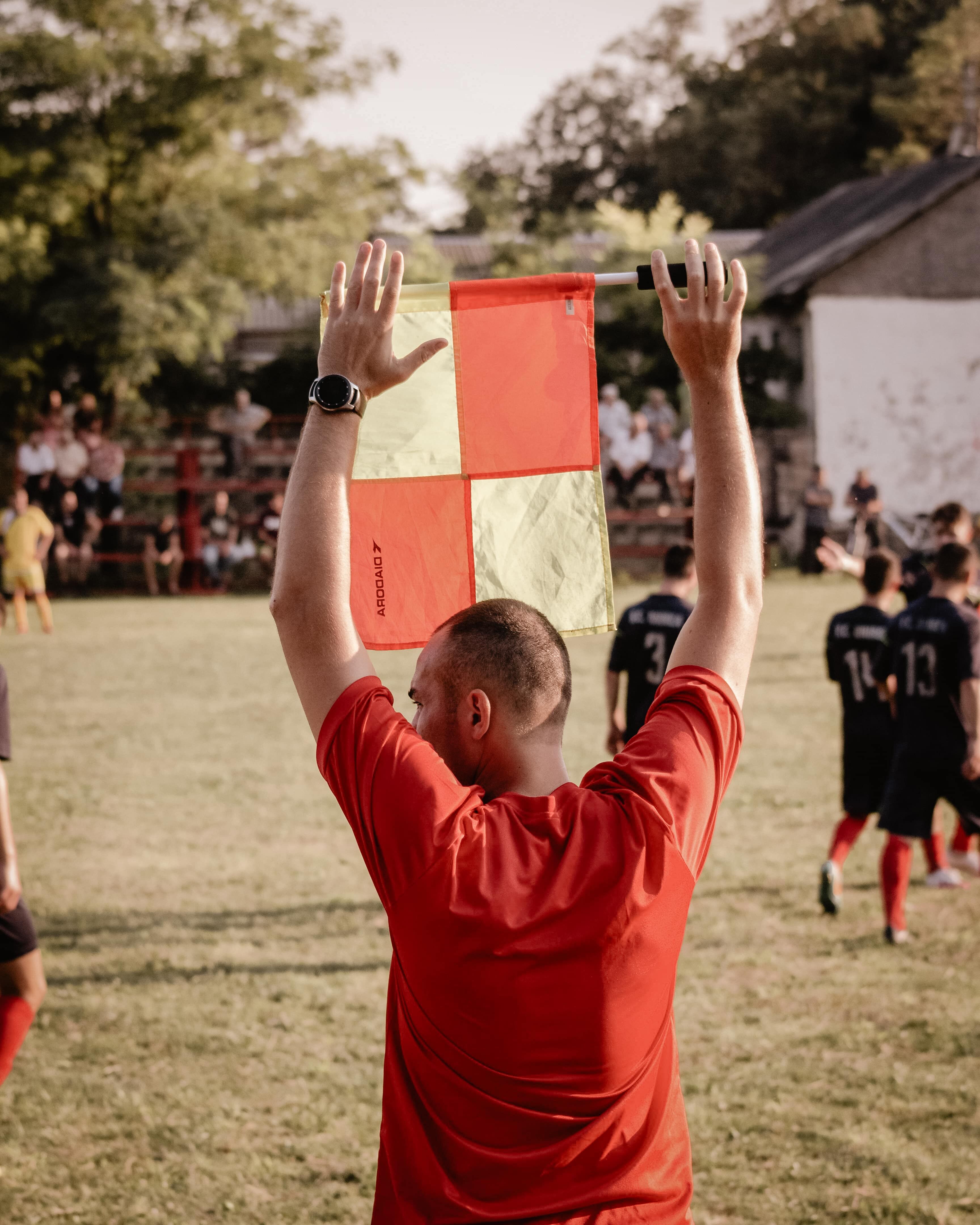 Assistant referee holding a flag on a football field